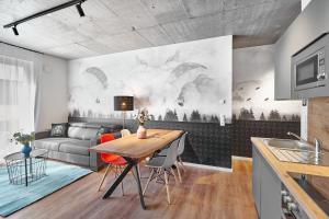 a kitchen and living room with a table and a couch at The Cloud Suite Apartments in Freiburg im Breisgau
