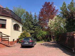 a car parked in a driveway next to a house at Villa 37b Bed and Breakfast in Warsaw
