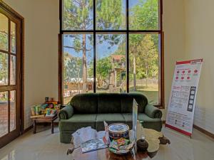 a living room with a green couch and a table at Super OYO 3208 Villa Inn App Trawas Bintaro Syariah in Kemloko-gede