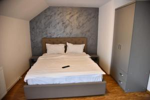 a small bedroom with a bed with a white mattress at Casa Sophia Maria in Caciulata