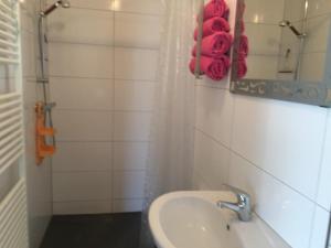 ein Badezimmer mit Waschbecken, Spiegel und roten Handtüchern in der Unterkunft Ferienwohnung Rosi Stoppa in Burg