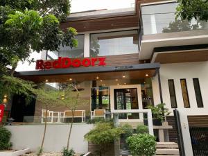 un restaurante de puerta roja con un cartel en el edificio en RedDoorz at Anton's Loft Designer Resort Pansol Calamba Laguna, en Laguna