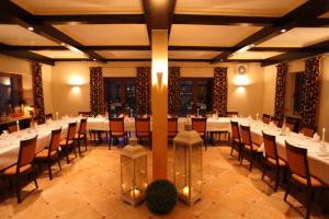 un salón de banquetes con mesas y sillas blancas en Hotel-Landgasthaus Ständenhof, en Ruppertsweiler