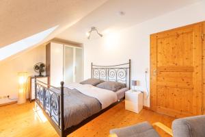 a bedroom with a bed and a wooden floor at Perfekt für Gruppen, Familien & Geschäftsreisende - Nähe Bamberg & Erlangen in Adelsdorf