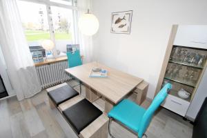 una sala da pranzo con tavolo in legno e sedie blu di Ferienpark K0E-007 Ferienpark a Heiligenhafen