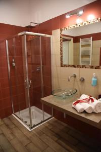 a bathroom with a glass shower and a sink at B&B The Queens in Foggia