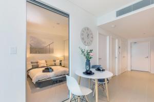 a bedroom with a bed and a table and a clock at KOZYGURU SKYTOWER BRISBANE CBD 2 BED APT QBN222-1815 in Brisbane
