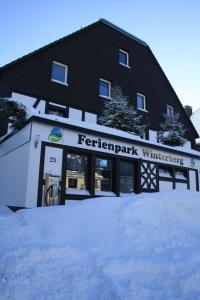 een zwart-wit gebouw met sneeuw ervoor bij Ferienpark Winterberg in Winterberg
