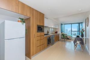 a kitchen with a refrigerator and a table in it at KOZYGURU SKYTOWER BRISBANE CBD 2 BED APT QBN222-1815 in Brisbane