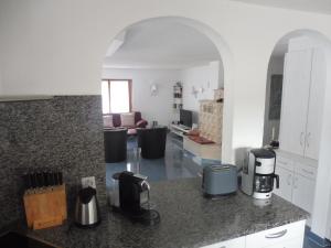 eine Küche mit einer Arbeitsplatte und ein Wohnzimmer in der Unterkunft Apartment Theresli First Floor in Saas-Almagell