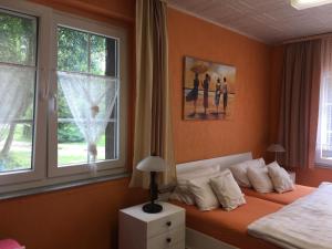 a bedroom with a bed with orange walls and windows at Ferienwohnung Rosi Stoppa in Burg