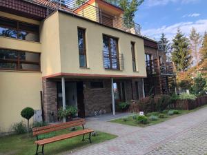 a building with a bench in front of it at Apartament Morski in Rewal