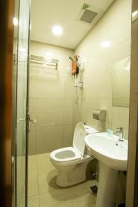 a bathroom with a toilet and a sink at Expo Hotel in Labuan