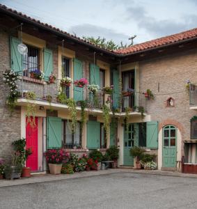 eine Reihe von Häusern mit grünen Türen und Blumen in der Unterkunft La Lepre Danzante in Borgomale