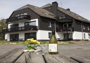 Una botella de vino y dos copas en una mesa de madera. en Ferienpark Winterberg, en Winterberg