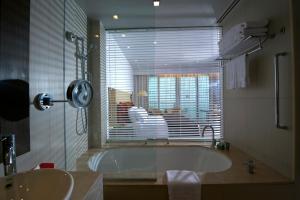 a bathroom with a tub, sink and shower at Crowne Plaza Yas Island, an IHG Hotel in Abu Dhabi