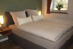 1 cama en un dormitorio con 2 lámparas y una ventana en Ferienwohnung Lodberger Scheunencafe, en Löningen