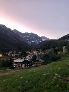 une ville sur une colline avec des montagnes en arrière-plan dans l'établissement Il piccolo rifugio - Casa Valtournenche, à Valtournenche