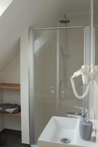 a bathroom with a shower and a sink at Ferienwohnung Lodberger Scheunencafe in Löningen
