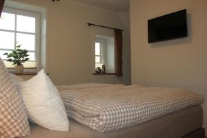 1 dormitorio con 1 cama y TV en la pared en Ferienwohnung Lodberger Scheunencafe, en Löningen