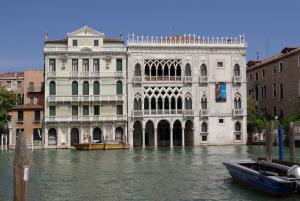 un edificio sull'acqua con una barca davanti di Ca' Puccetti a Venezia