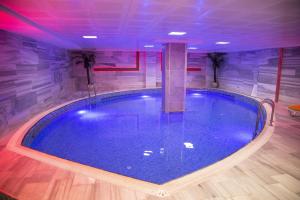 a large swimming pool in a room with purple lights at Buyuk Velic Hotel in Gaziantep