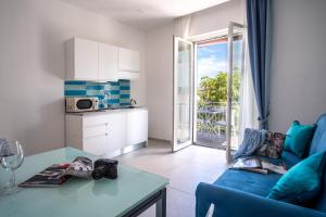 un soggiorno con divano blu e tavolo di LEONE ROSSO APARTMENTs a Sorrento