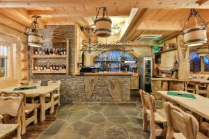 un restaurant avec des tables en bois et un bar dans l'établissement Pensjonat pod Kotelnicą, à Białka Tatrzańska