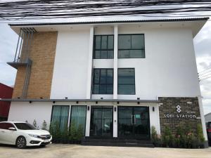 a white building with a car parked in front of it at Loei Station in Loei