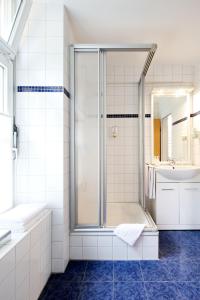 a bathroom with a shower and a tub and a sink at Hotel Marienhof Baumberge in Nottuln