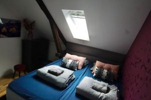 a bedroom with a bed with blue sheets and pillows at Ålesund downtown loft room with shared bathroom in Ålesund