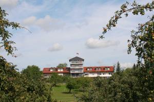 a building in the middle of a field with trees at Gaestehaus Zum Wolffenturm 