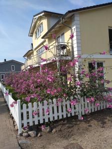 una recinzione bianca con fiori rosa di fronte a una casa di Haus Malve Dahme a Dahme