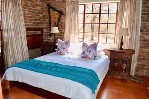Un dormitorio con una cama blanca con almohadas. en Athule Inn Marloth - House, en Marloth Park 12 fotos más