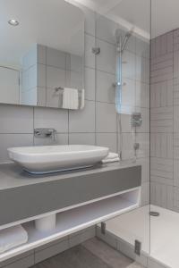a white bathroom with a sink and a shower at Holiday Inn - Lusaka, an IHG Hotel in Lusaka