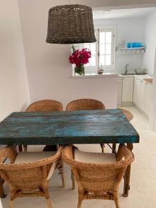 a dining room table with chairs and a kitchen at Es Chalet in Sant Lluis