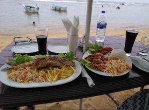 a table with two plates of food on the beach at Coral Reef Guest in Beruwala