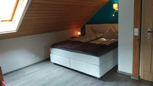 a small bed in a room with a wooden ceiling at Ferienwohnung Susanne & Georg Guth in Beilngries