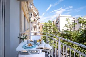 balkon ze stołem z jedzeniem i książką w obiekcie LEONE ROSSO APARTMENTs w Sorrento