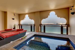 a swimming pool in a room with a couch and a table at Arjaan by Rotana - Dubai Media City in Dubai