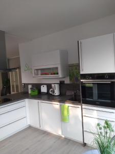 una cucina bianca con armadietti e elettrodomestici bianchi di Haus Malve Dahme a Dahme