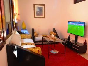 a living room with a couch and a flat screen tv at DAR AZIZ in Marrakesh
