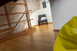 Habitación con pared de ladrillo y silla negra. en Loft Mirano Uno (Alloggi alla Campana), en Mirano