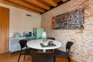 uma sala de jantar com uma mesa branca e cadeiras em Loft Mirano Uno (Alloggi alla Campana) em Mirano