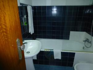a bathroom with a sink, toilet and bathtub at Residencial Arabi in Portimão