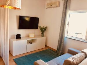 a living room with a tv and a couch at Atlantic Luxury Apartment - Praia da Rocha in Portimão