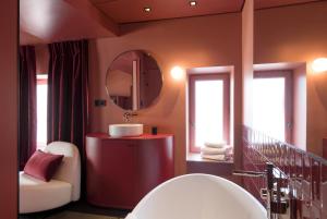 a bathroom with a large mirror and a tub at MiHotel Tour Rose in Lyon