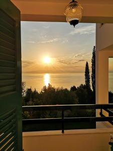 a view of the sunset from the balcony of a house at Nikoli Apartments in Benitses