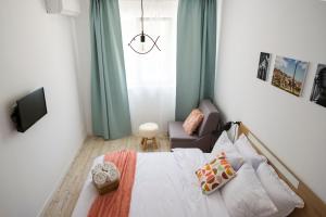 a bedroom with a bed and a chair and a window at Tarno Guest House in Veliko Tŭrnovo