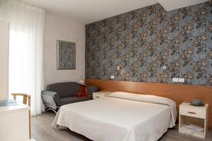 リド・ディ・イエゾロにあるHotel Rosaのベッドルーム1室(ベッド1台、椅子付)